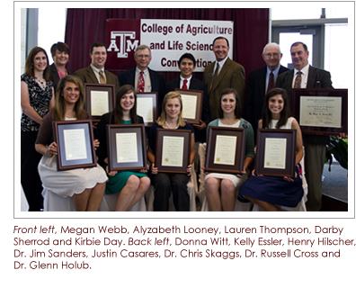 Group of faculty and students standing in front of a backdrop holding awards.