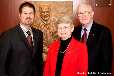 Artist Scott Myers, Kay Hesby and Dr. Russell Cross standing at the unveiling of the relief sculpture.