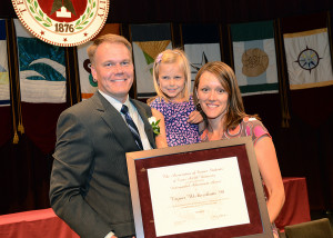 Tryon Wickersham with his family. He is holdng an award.