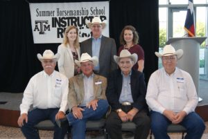 People standing and sitting for a photo inside the AgriLife Center. Pictured (front left) Dr. Doug Householder, Dr. Pete Gibbs, B.F. Yeates and Dr. Gary Potter. (Back left) Chelsie Huseman, Dr. Dennis Sigler and Jennifer Zoller.
