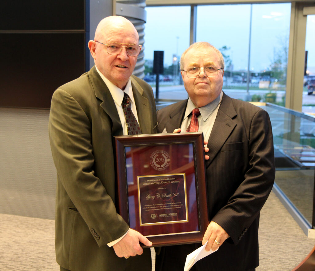 Rod Bowling, Ph.D., right, presents the Animal Science Outstanding Alumni Award to Gary C. Smith ’68.