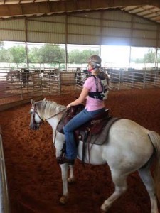 Animal science graduate student Colleen O’Reilly wears portable equipment allowing researchers to monitor oxygen consumption, carbon dioxide output and caloric expenditures while riding her horse in an arena.