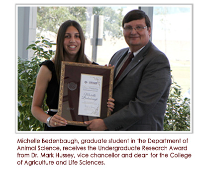 Michelle Bendenbaugh, graduate student in the Department of Animal Science, receives the Undergraduate Research Award from Dr. Mark Hussey, vice chancellor and dean for the College of Agriculture and Life Sciences.