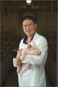 Dr. Guoyao Wu holding a pig.