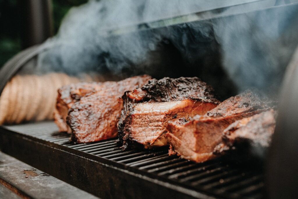 Barbecue being smoked in a barbecue pit.
