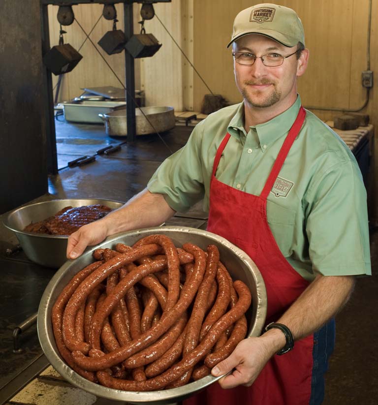 Bryan Bracewell holding a bowl of sausage.