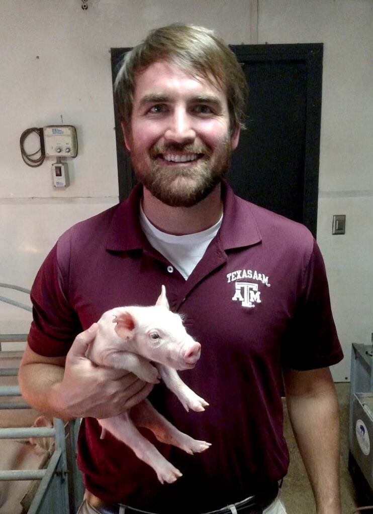 Dr. Chad Paulk holding a piglet.