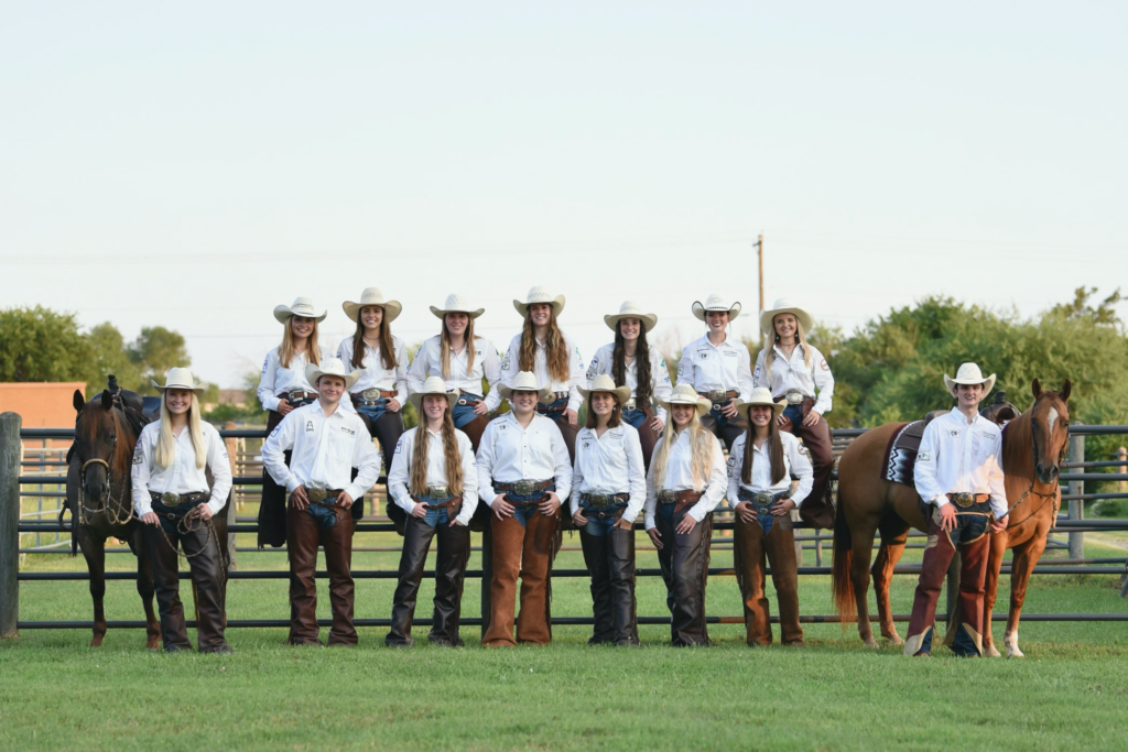 Ranch horse team standing together for team picture with 2 horses on each side. 