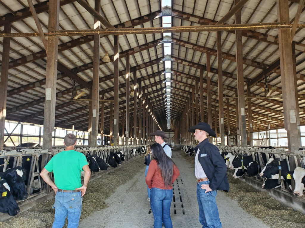 A small group of people standing in a large barn