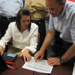 Two auditors examining a spreadsheet