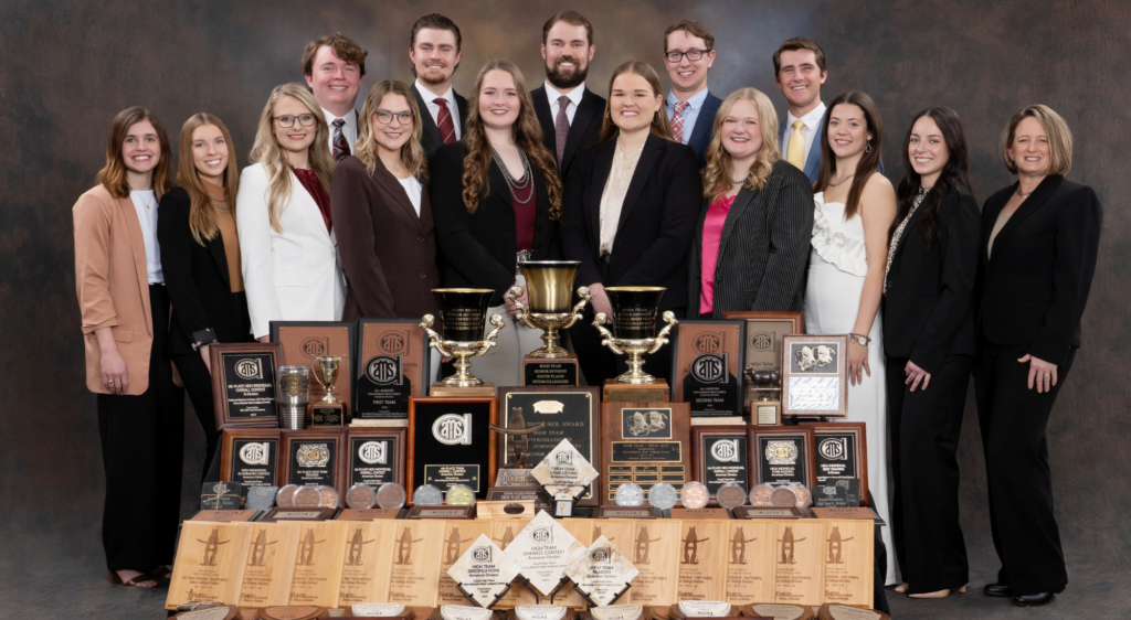 Meat judging team members stand with trophies, ribbons and plaques from the 2024 spring season.