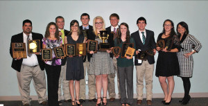 Group of students standing while holding their awards and plaques.