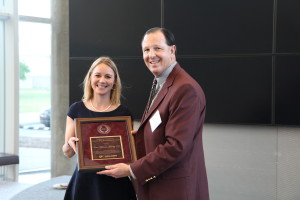 Erin Hawley holding an award. Standing with her is Dr. Chris Skaggs.