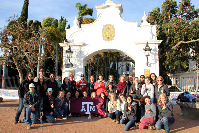 Students standing outside the San Pedro de Timote. Some at the bottom are holding a Texas A&M flag.