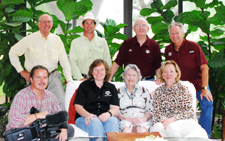Dr. Riggs sitting with a group of people looking at the camera.