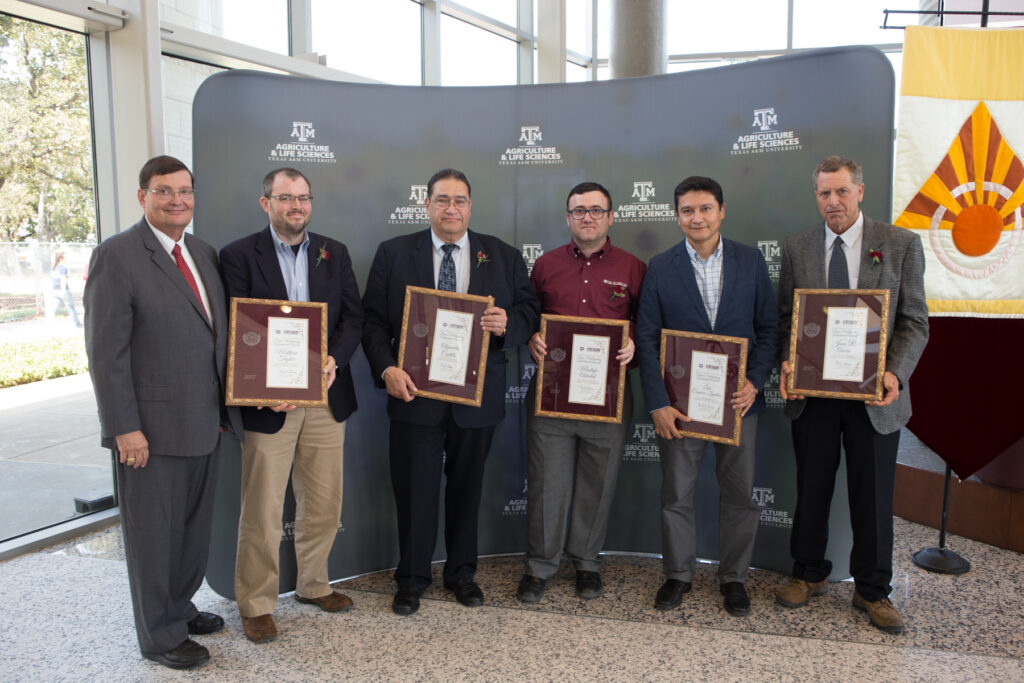 A group standing with their awards.