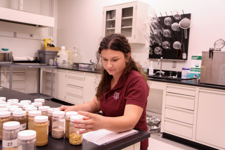 Alyson reviewing feedstuffs prior to teaching ANSC 318 lab.