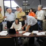 A group of auditors looking at a computer together
