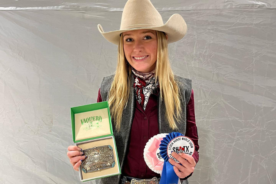 student posing with awards
