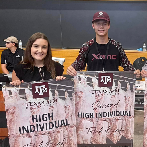 Girl holding "high individual" banner next to boy holding "Second high individual" banner.