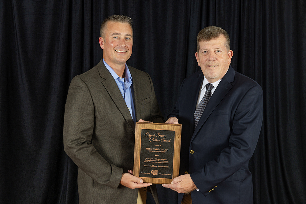 two men in suit and ties holding Signal Service Fellow award