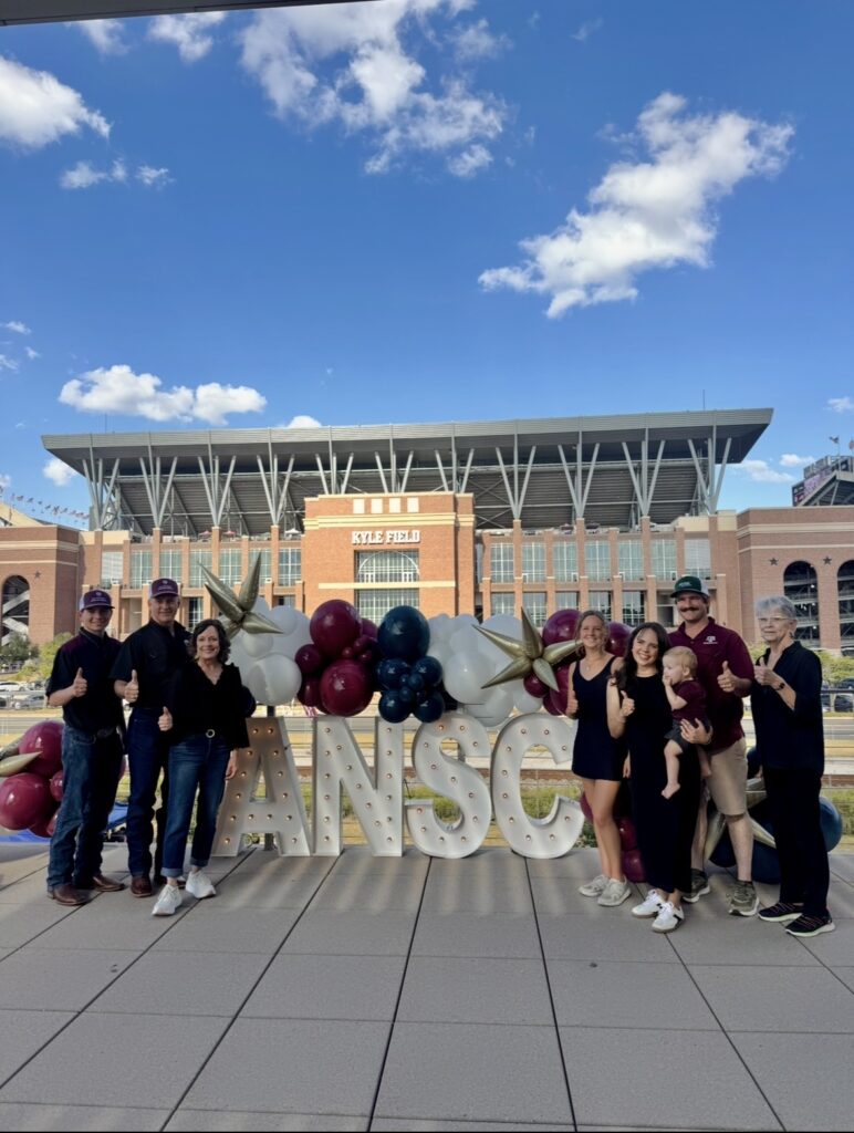 Dr. Mathis, Department Head, and his family posing for a photo at the Texas A&M Animal Science Tailgate